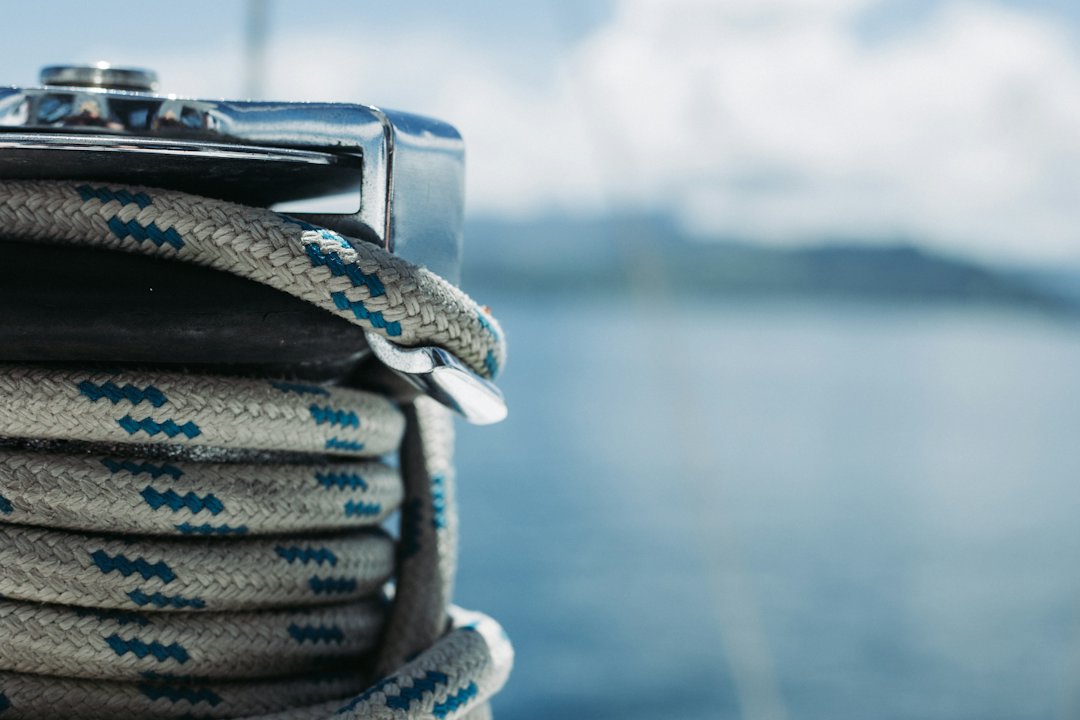 Drisse lovée sur un winch de voilier, mer en arrière-plan